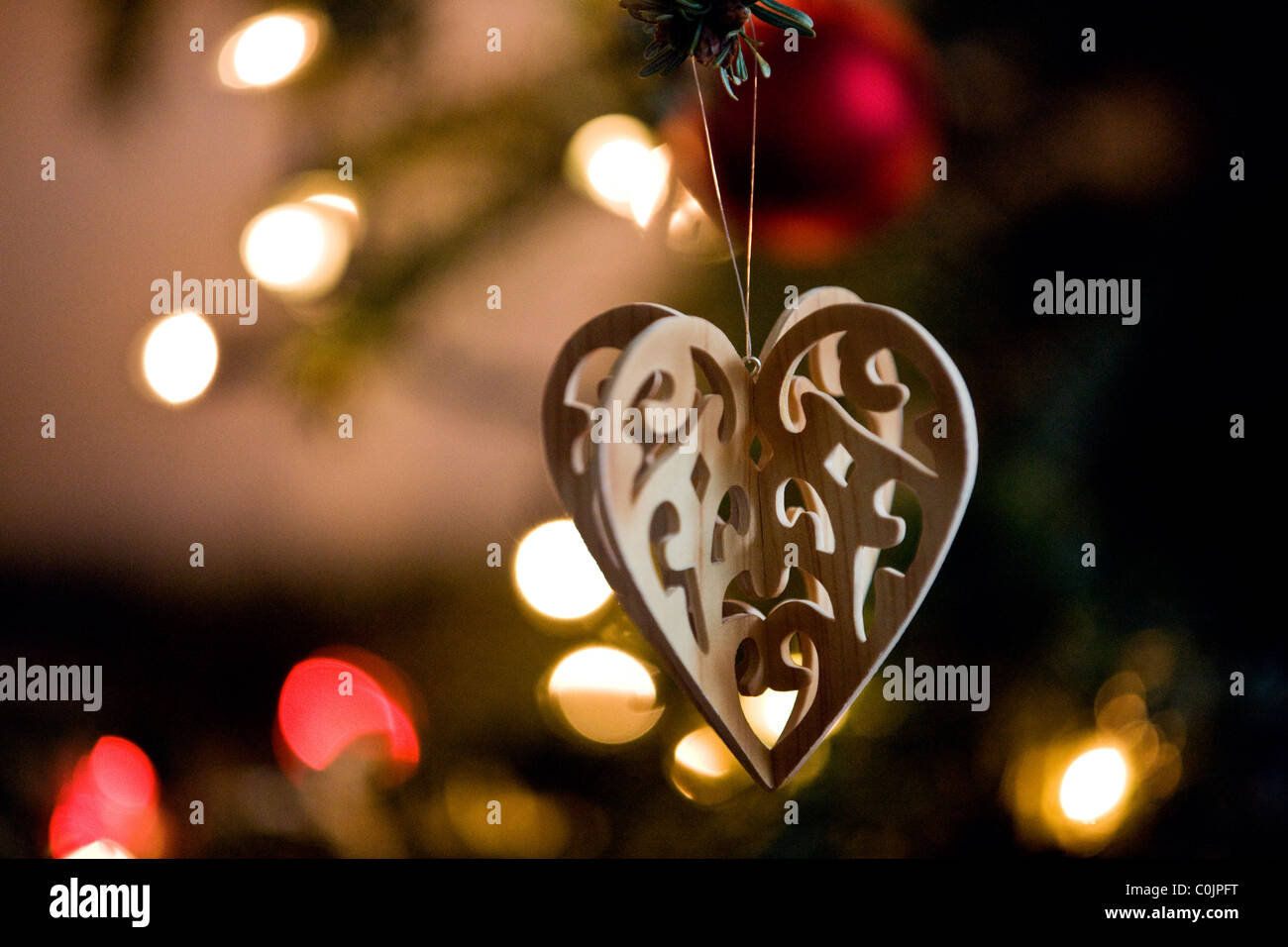 A wooden heart shaped decoration hanging on a Christmas tree Stock Photo