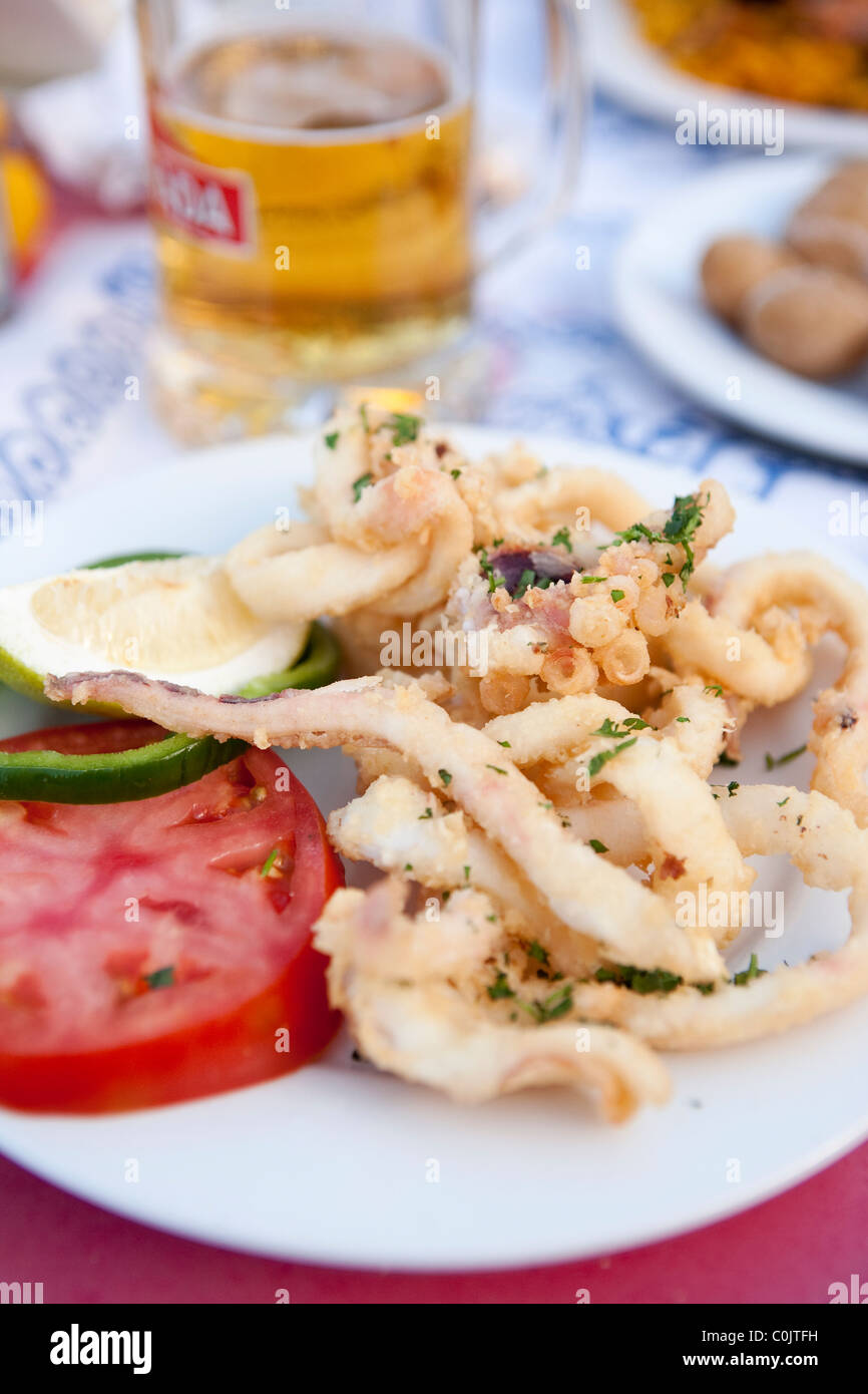 calamari squid tomato lime tapas meal dish plate beer Stock Photo