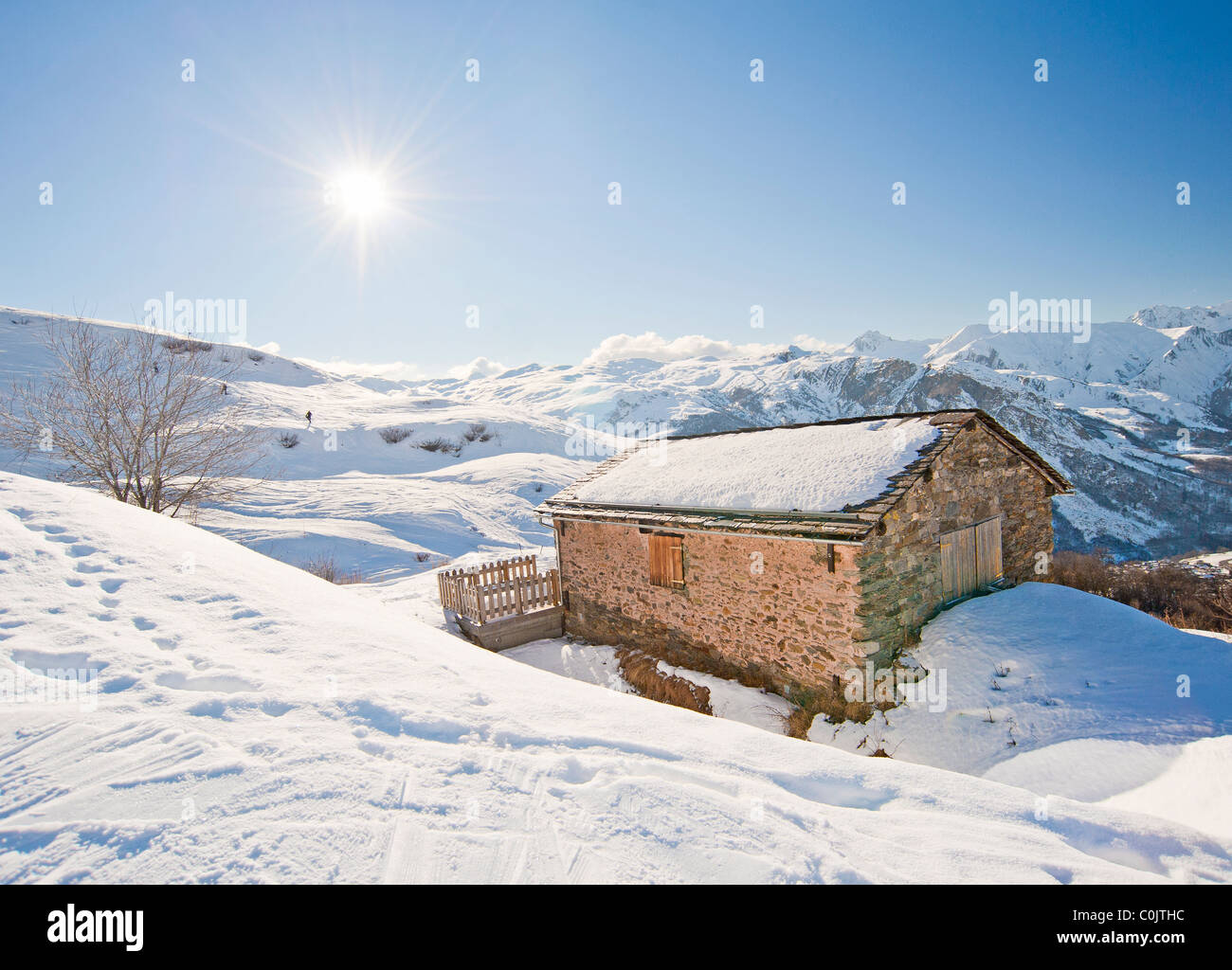 Remote mountain hut on a slope in the sunlight Stock Photo