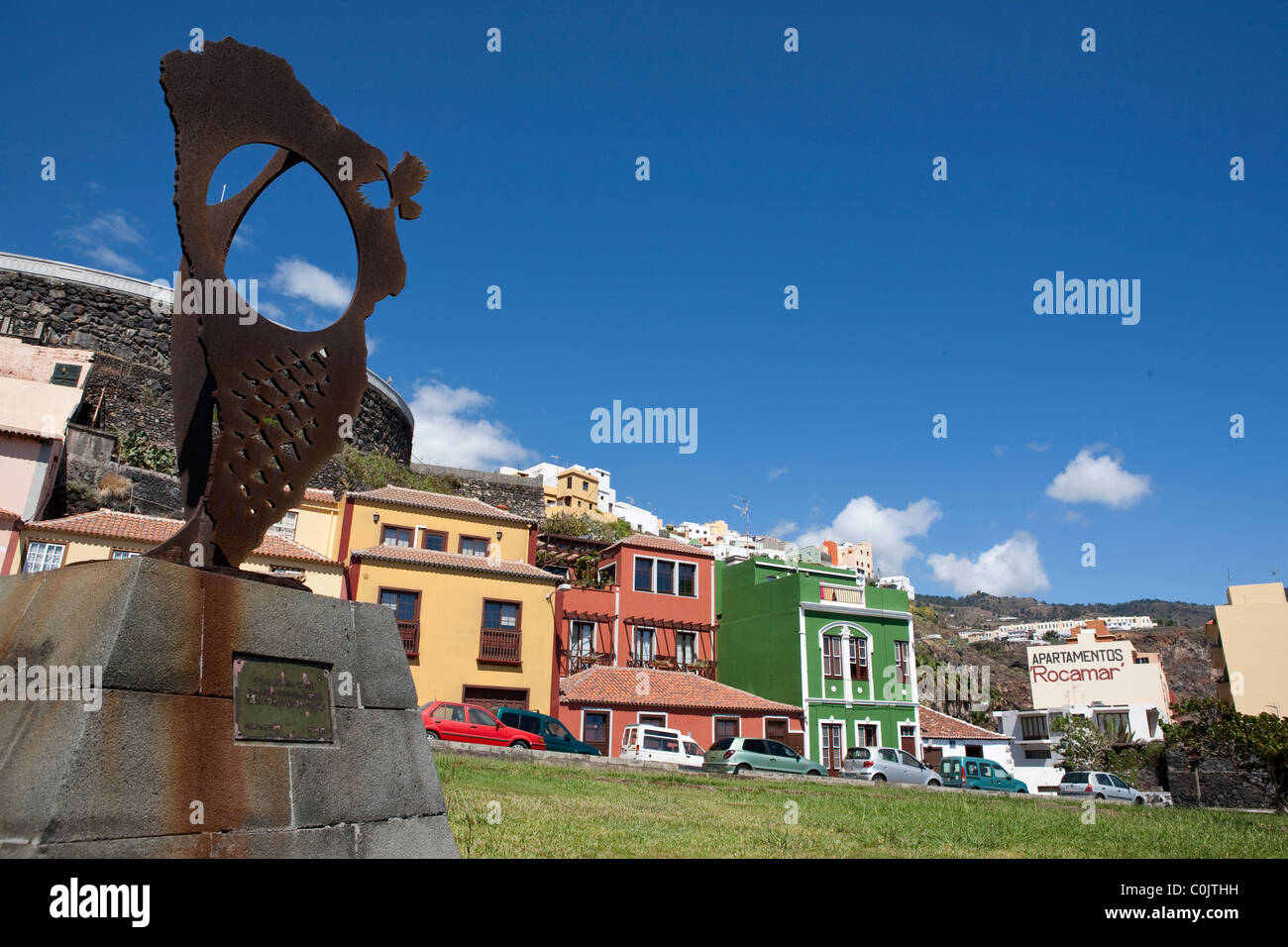Island monument and colourful buildings on seafront of Santa Cruz de la Palma Stock Photo