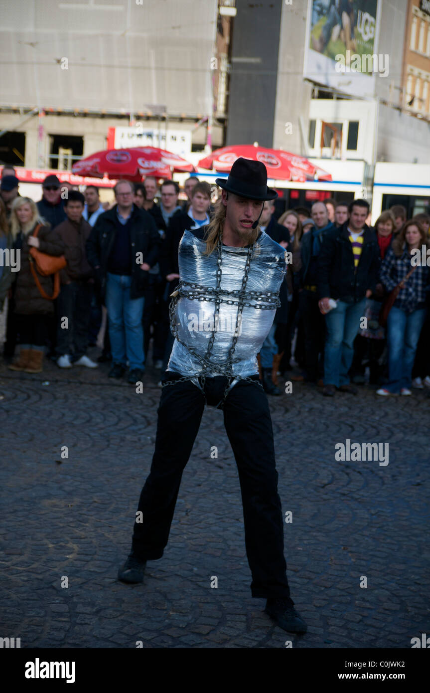 Street performer, escapologist performing for a crowd in Amsterdam Stock Photo