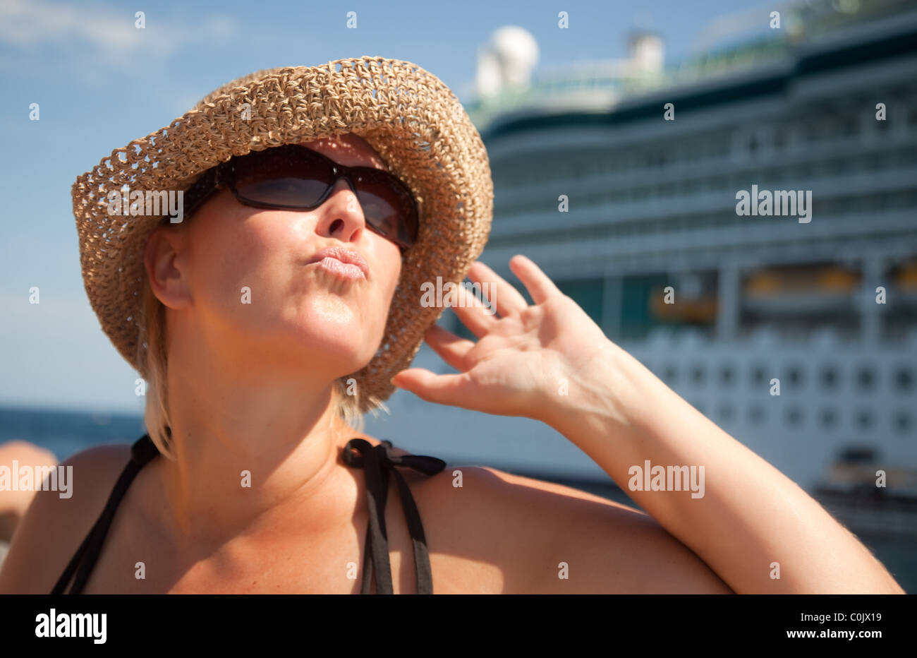 Beautiful Vacationing Woman on Tender Boat with Cruise Ship in the Background. Stock Photo