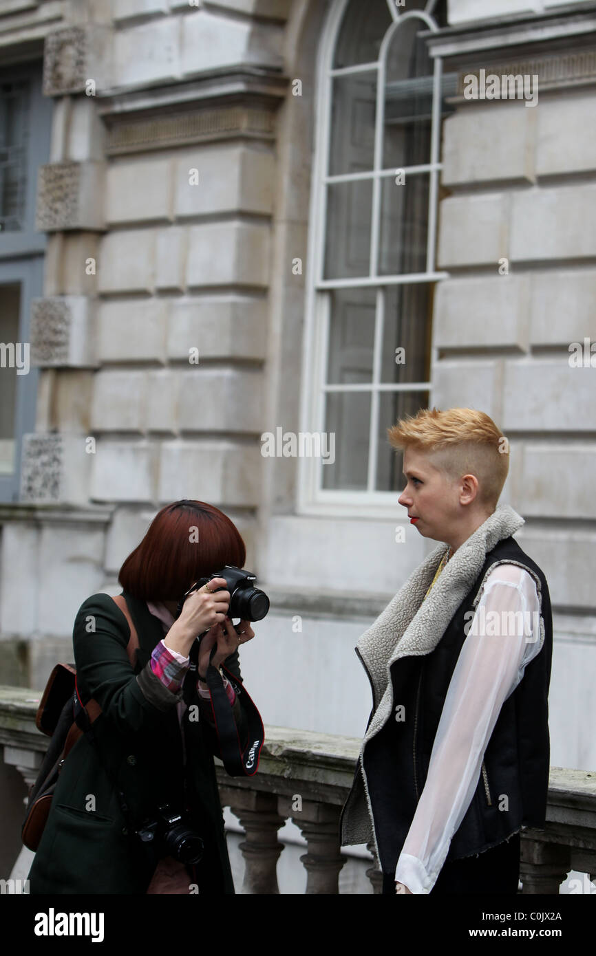 A young photographer shoots a blond short haired model at London Fashion Weeks 2011 event at Somerset House in London. Stock Photo