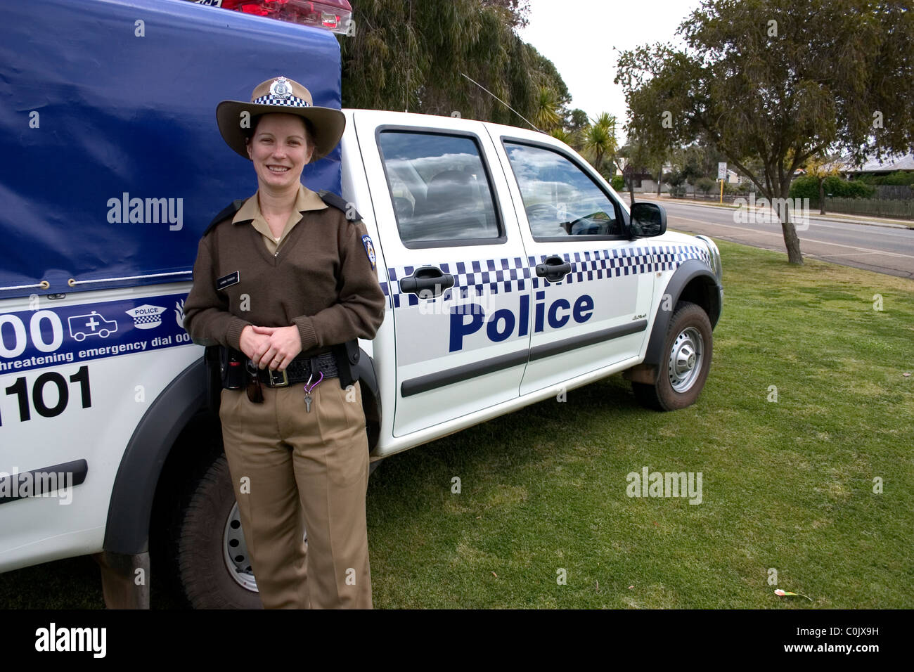 A police woman stands by vehicle Stock Photo