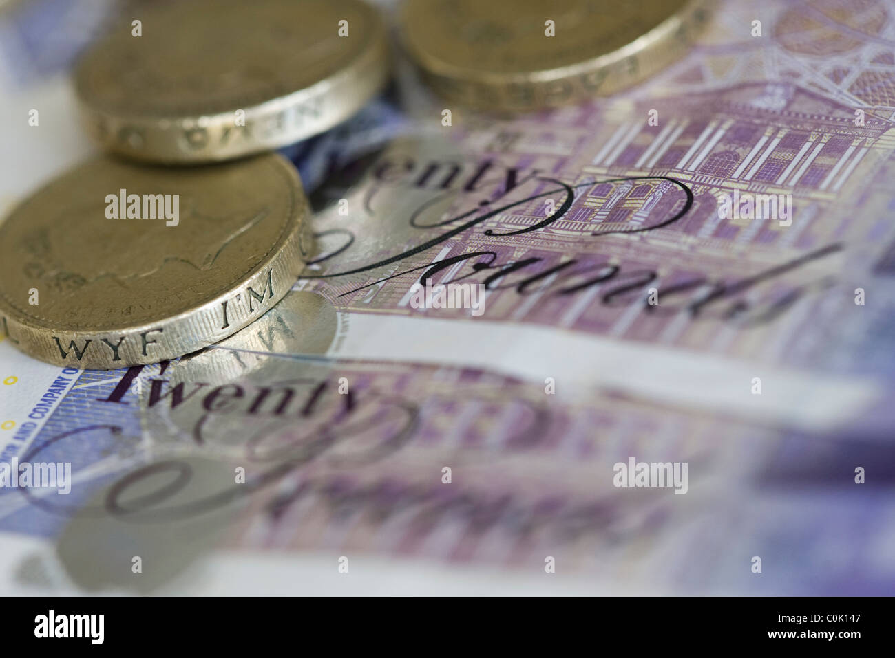 Twenty pound sterling notes and one pound coins are set up for a photograph Stock Photo