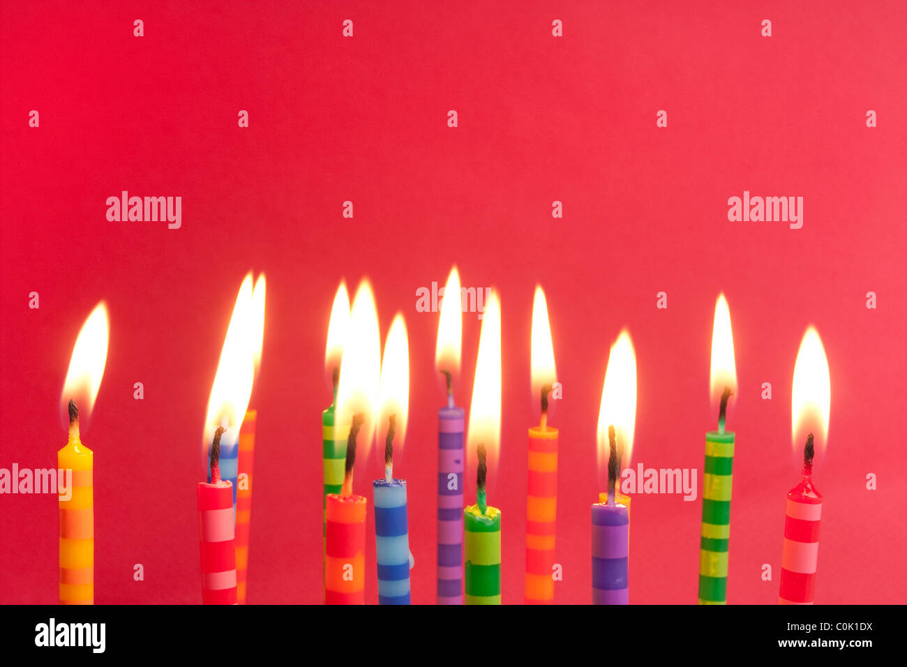 Candles alight on a red background, big group of striped designs Stock Photo