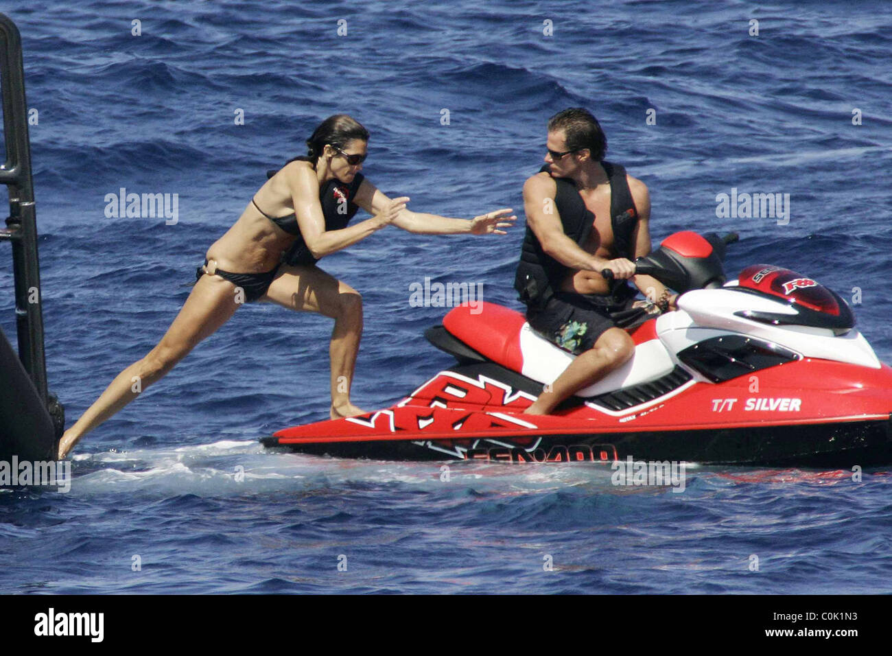 Cindy Crawford jumps on to a Jet Ski with husband Rande Gerber whilst  relaxing on holiday on a yacht in Porto Crevo Sardinia Stock Photo - Alamy