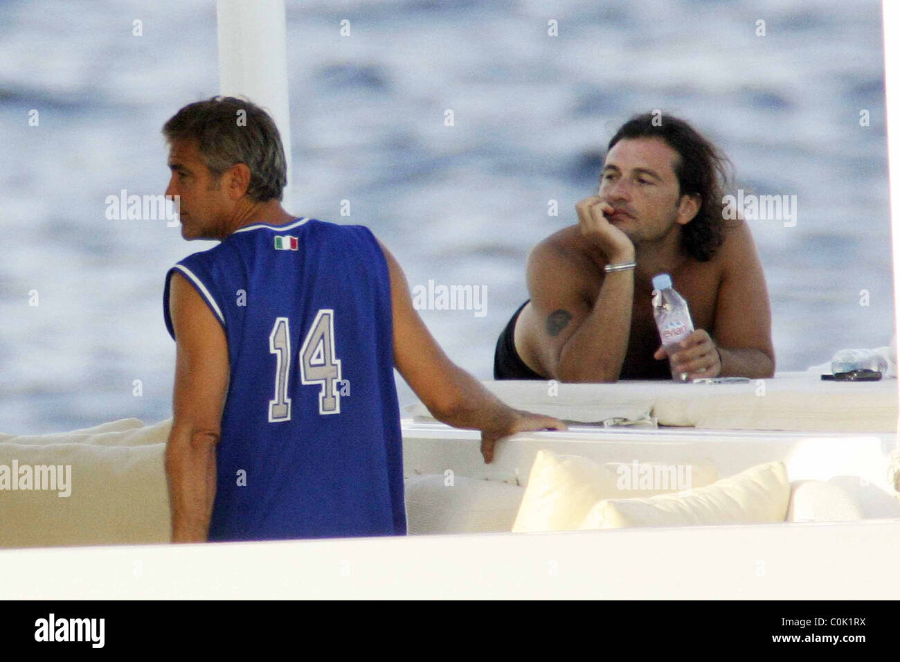 George Clooney wearing an Italia soccer vest and Manuele Malenotti whilst  relaxing on holiday on a yacht in Porto Crevo Stock Photo - Alamy