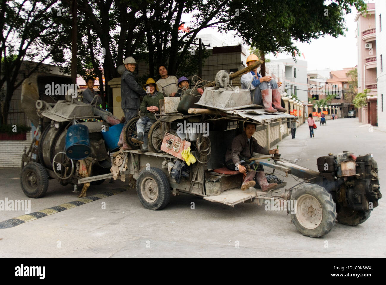 Chinese men/ peasants driving an extraordinary machine/ vehicle they obviously build themselves, Dongguan, China Stock Photo