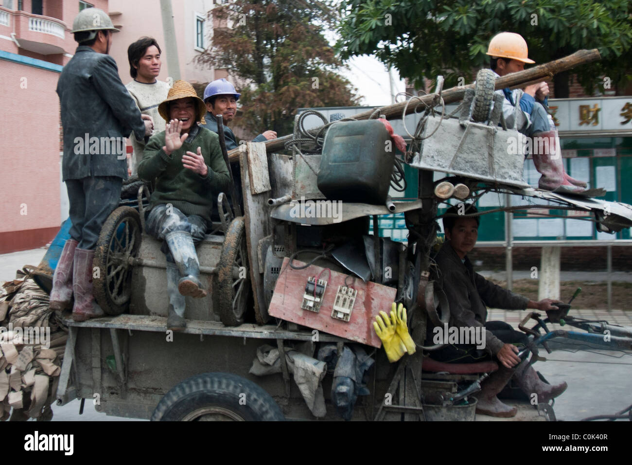 Chinese men/ peasants driving an extraordinary machine/ vehicle they obviously build themselves, Dongguan, China Stock Photo