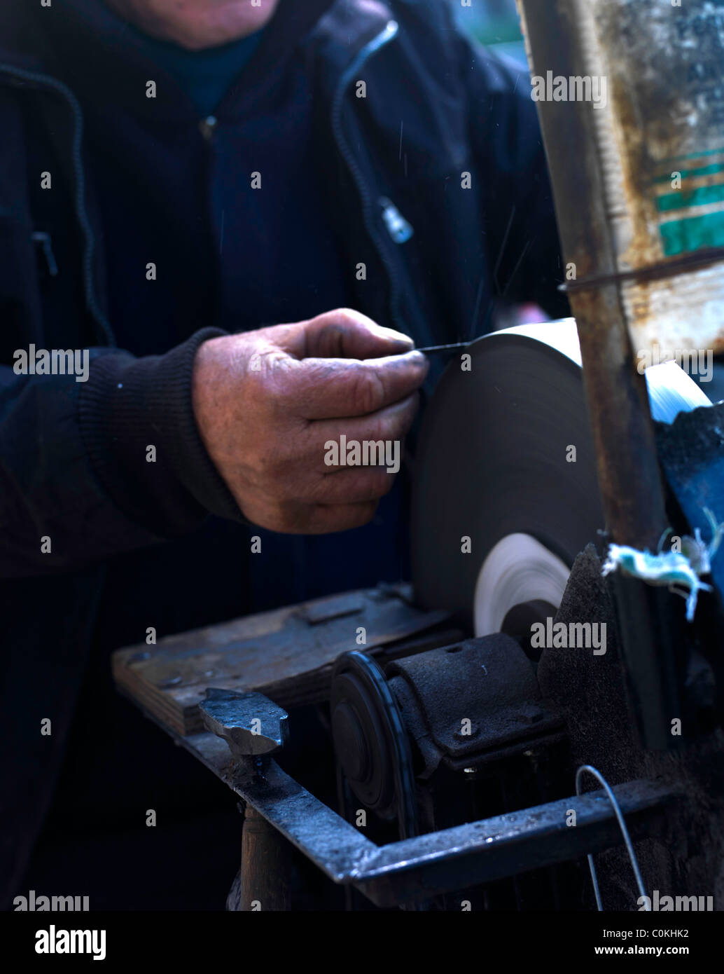 knife sharpening machine and master. Grinding machine. grinding knife using  abrasive stone Stock Photo - Alamy