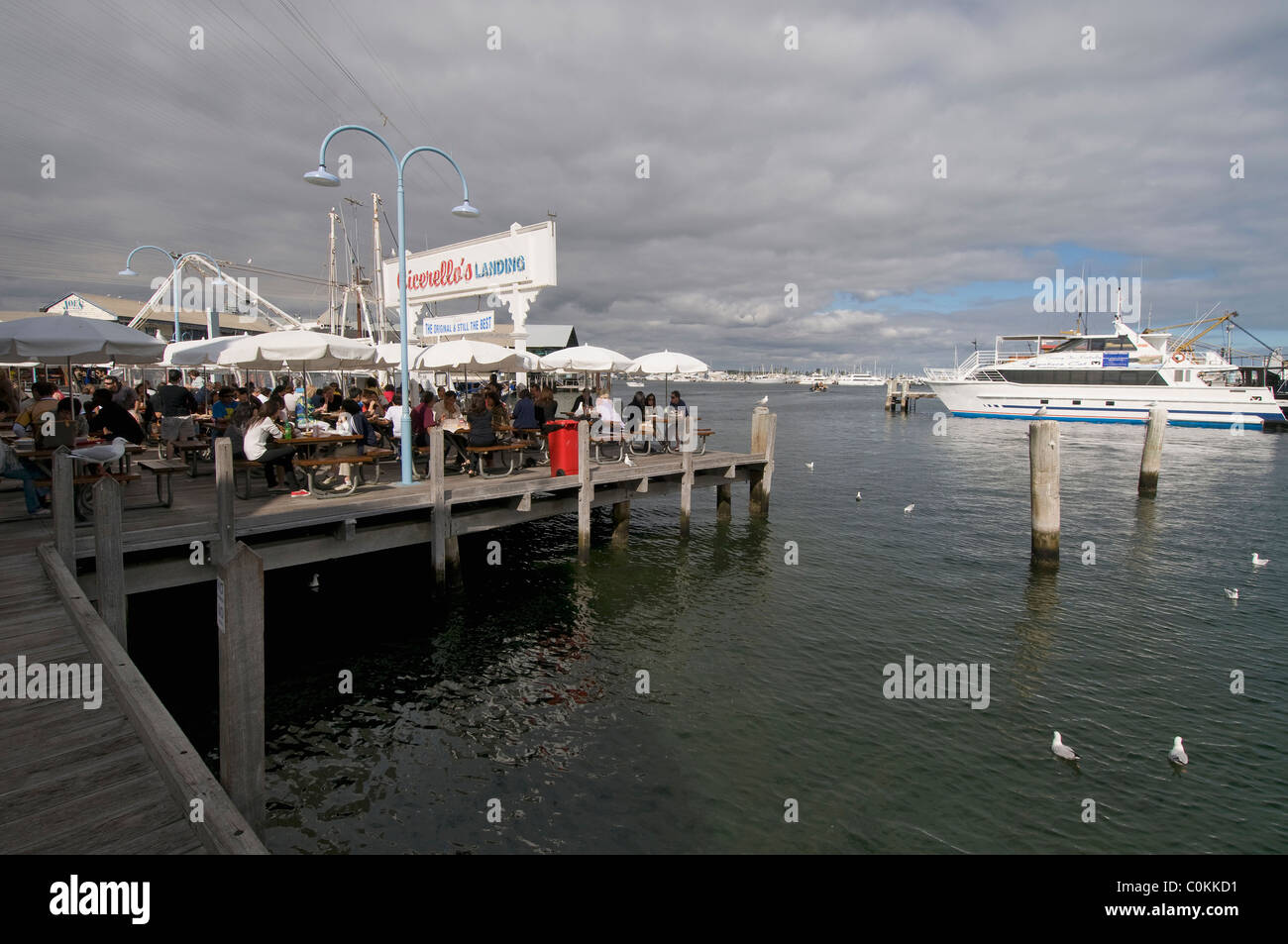 Visitors enjoying lunch at one of the restaurants on a jetty at  Fishing Boat Harbour in Fremantle, Western Australia. Stock Photo