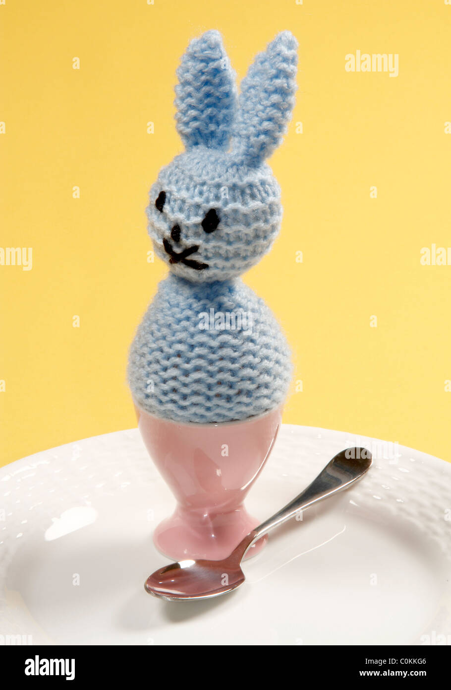 Cute Knitted Easter Bunny Egg Warmer with Pink Egg Cup Stock Photo