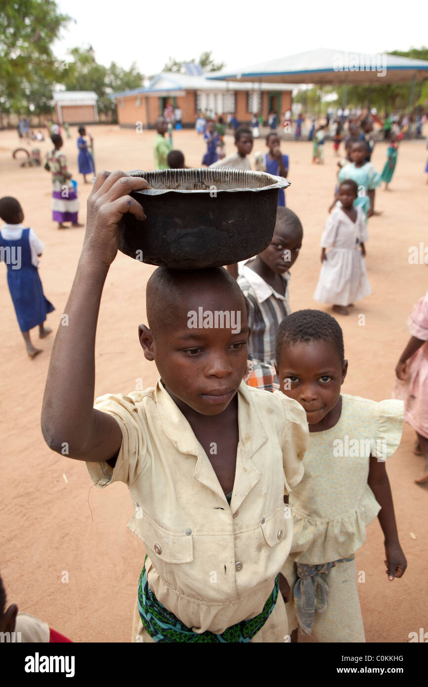 A child carries water back from a well at a UNICEF-funded orphanage in Dedza, Malawi, Southern Africa. Stock Photo