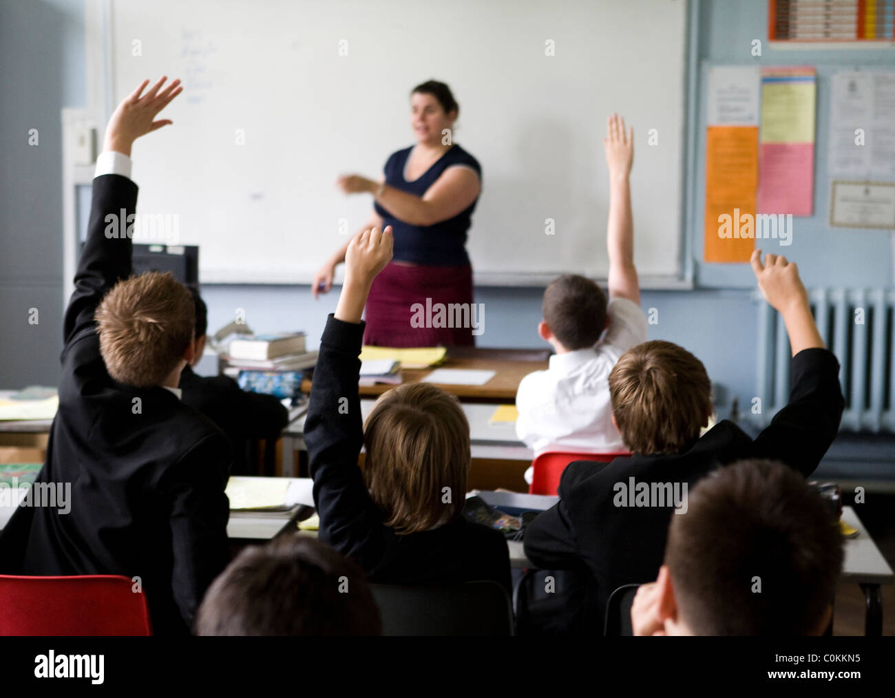 Pupils put up their hands to answer a questions at Maidstone Grammar school in Maidstone, Kent, U.K. Stock Photo