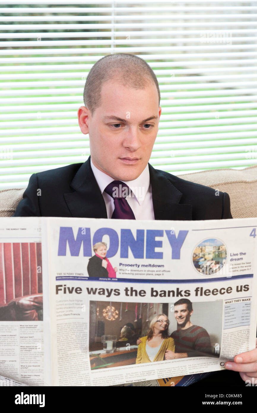 man reading money supplement  in newspaper in UK Stock Photo