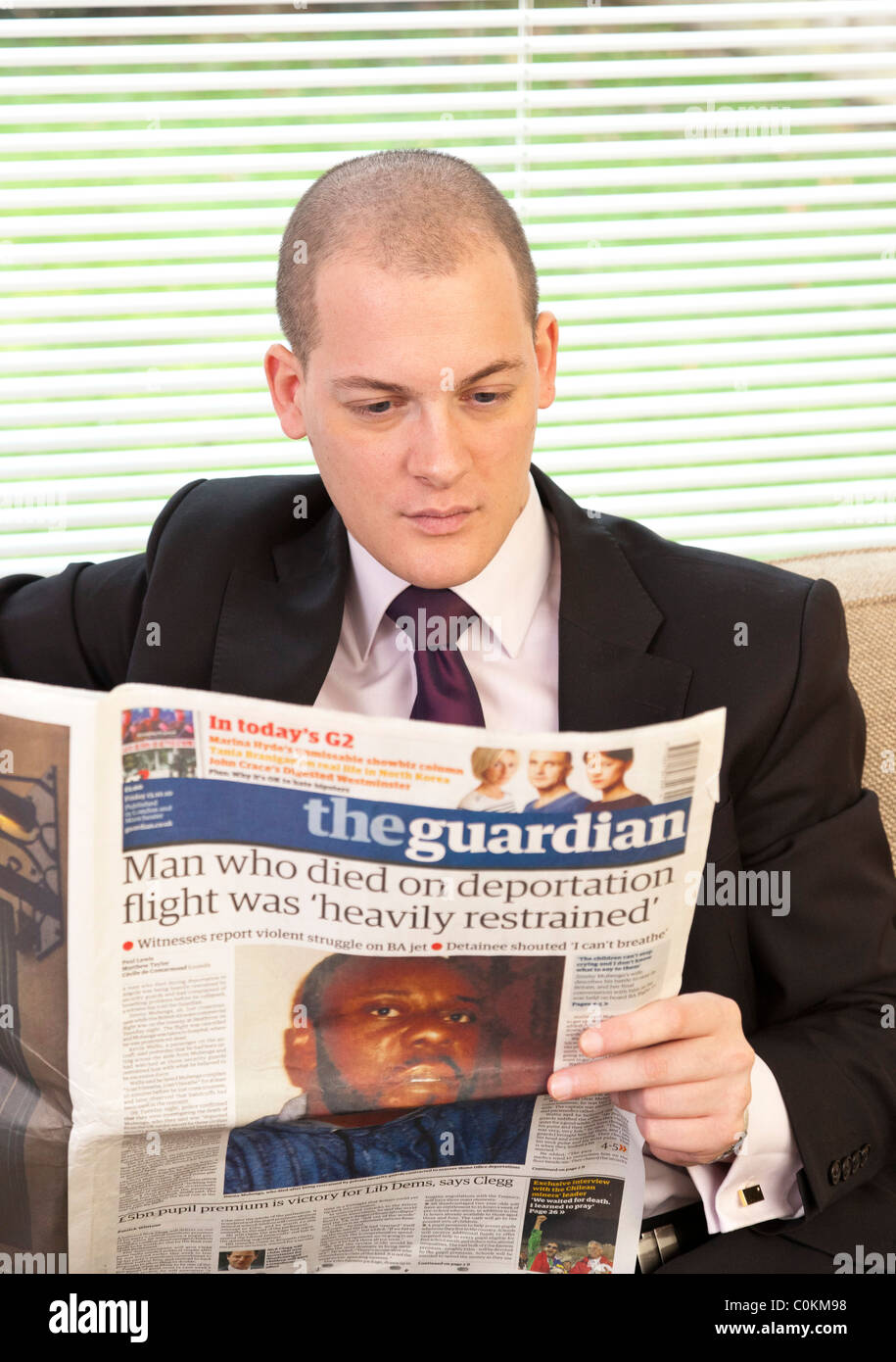 man reading The guardian newspaper in UK Stock Photo