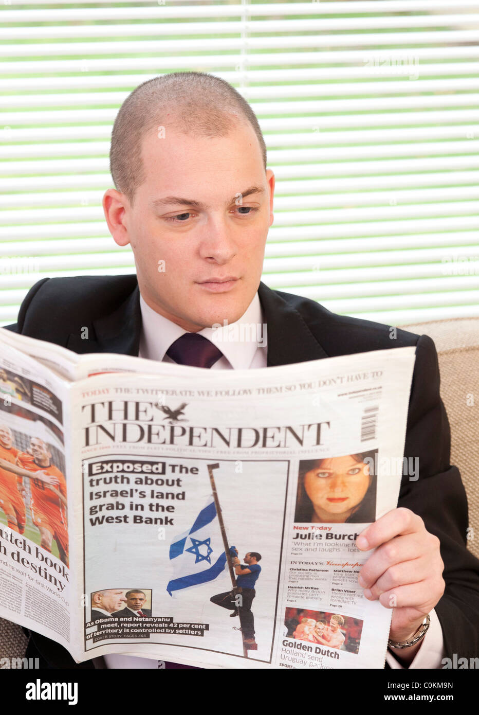 man reading The Independent newspaper in UK Stock Photo