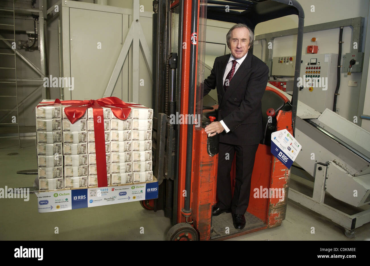 Sir Jackie Stewart with fork lift load of money Stock Photo