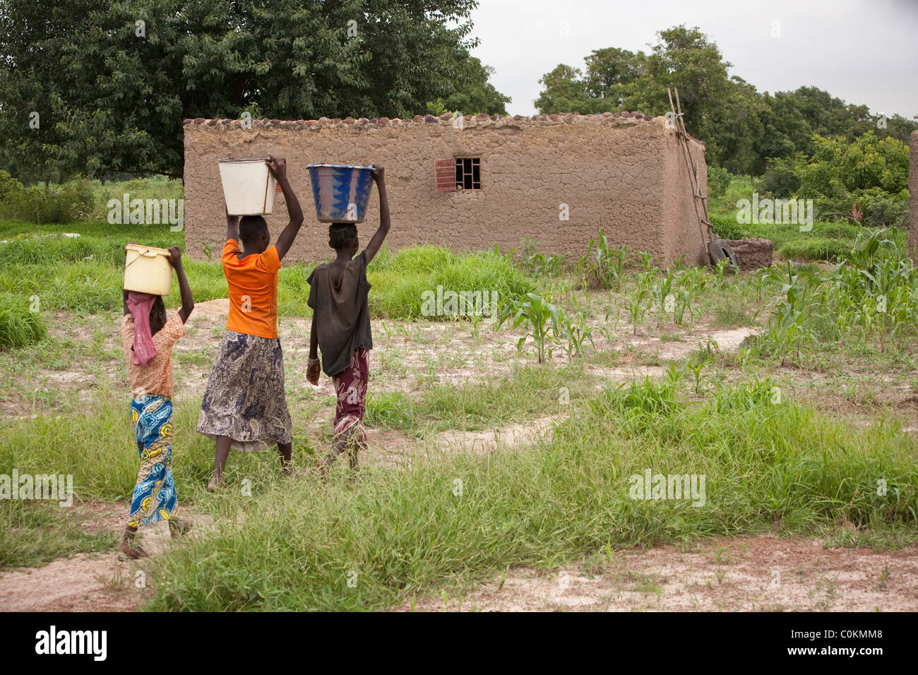 Girls bring water home from a well in Safo, Mali, West Africa. Stock Photo