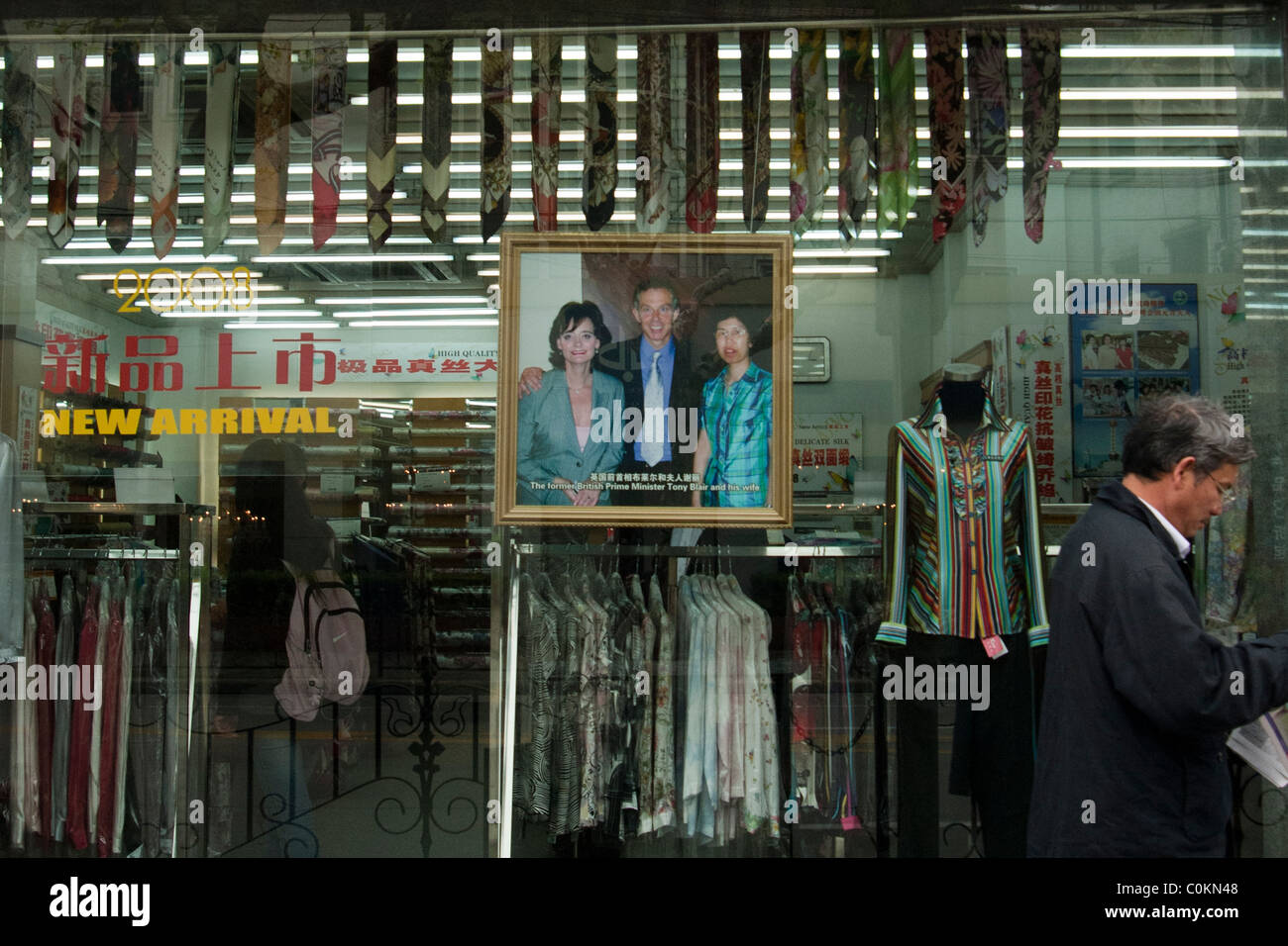 window display in Shanghai with a picture of Tony and Cherie Blair with a shop manager Stock Photo