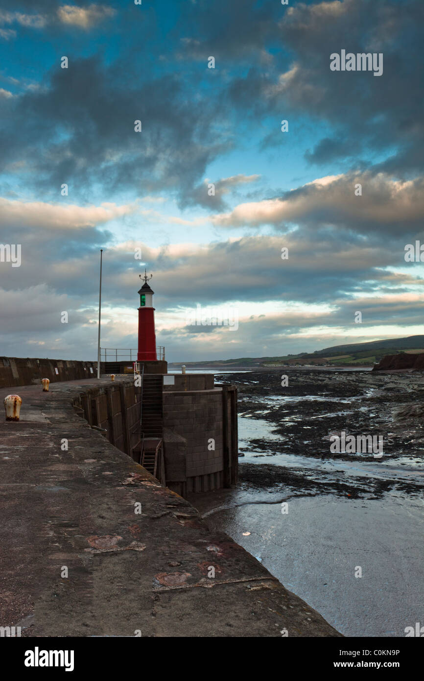 A view along the harbour edge toward the lighthouse at Watchett, Somerset, UK at sunset Stock Photo