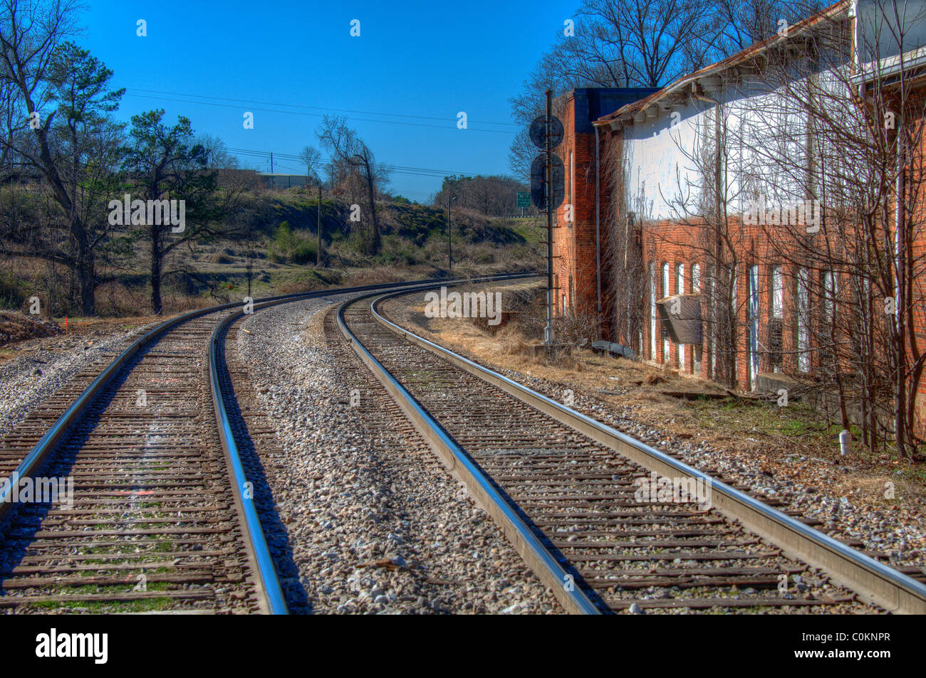 Old railroad tracks by a warehouse Stock Photo