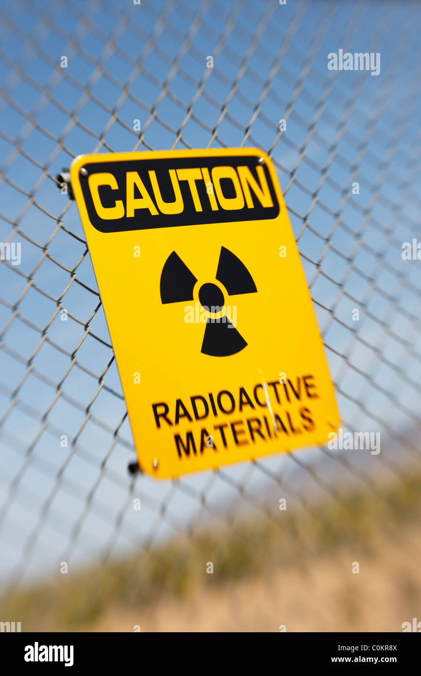 Radioactive materials sign on a wire fence, Trinity Site, New Mexico - selective focus. Stock Photo