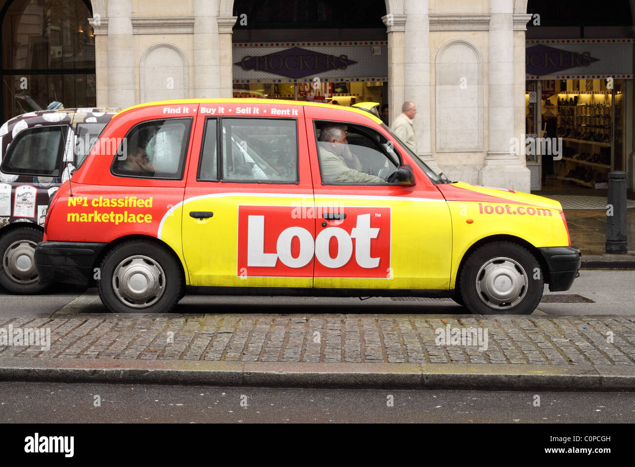 London taxi with Loot advert advertising colour scheme Stock Photo