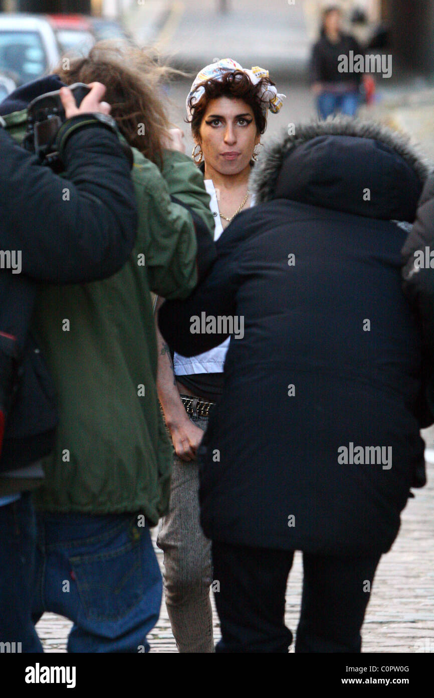 Amy Winehouse surrounded by paparazzi as she returns home from the pub with friends. London