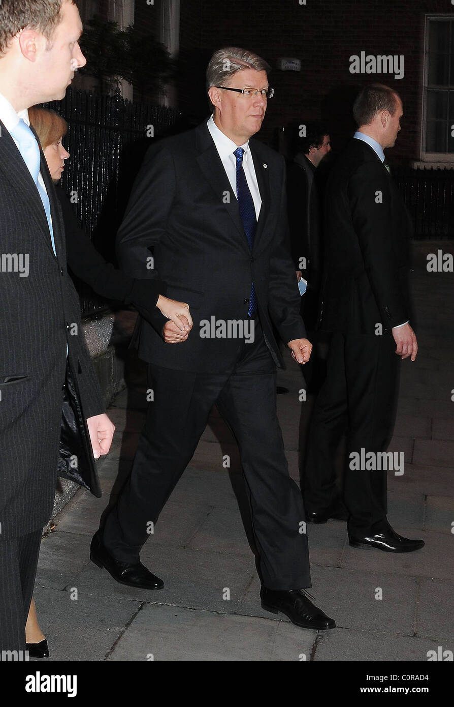 The president of Latvia Valdis Zatlers holding his wife Lilita Zatlere's hand while leaving The Merrion Hotel amid tight Stock Photo