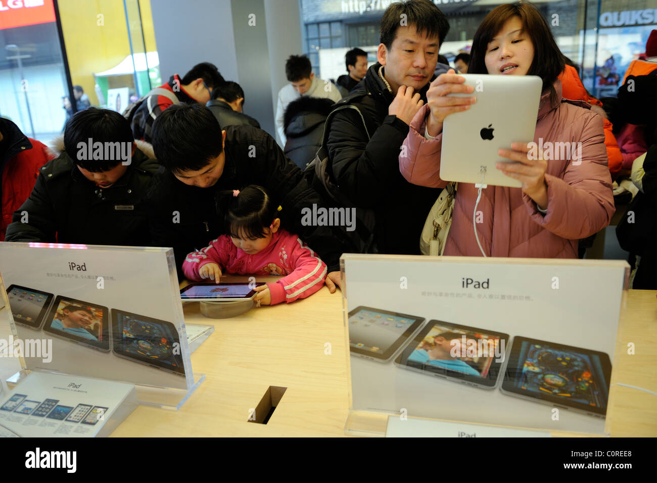 People trying out Apple iPad in the Apple Store in Beijing, China. 26-Feb-2011 Stock Photo