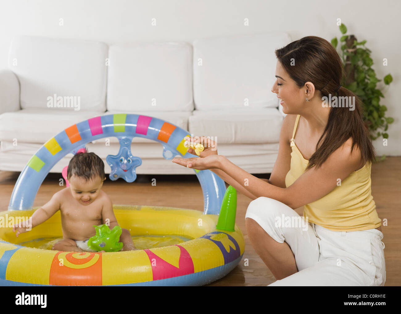Woman bathing her son in a wading pool Stock Photo
