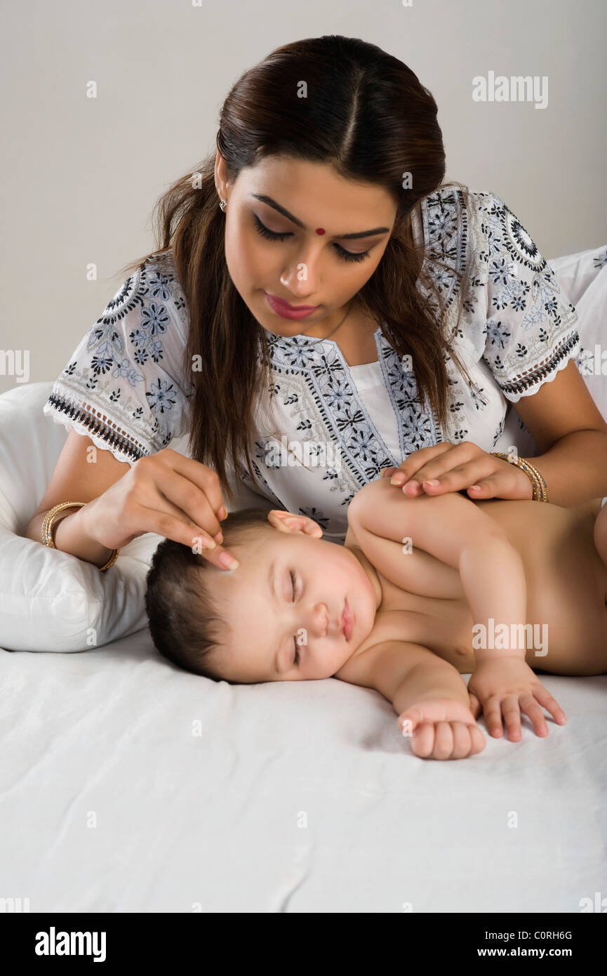 Woman applying kala tika on her son Stock Photo