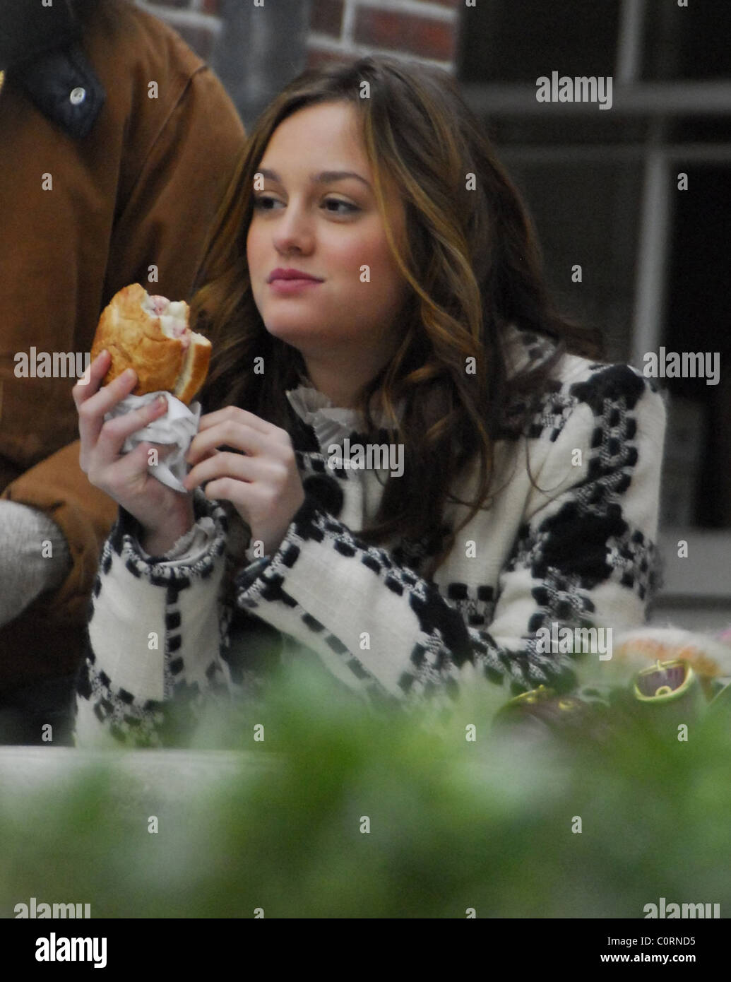 Leighton Meister eating a very large ham sandwich on the set of 'Gossip