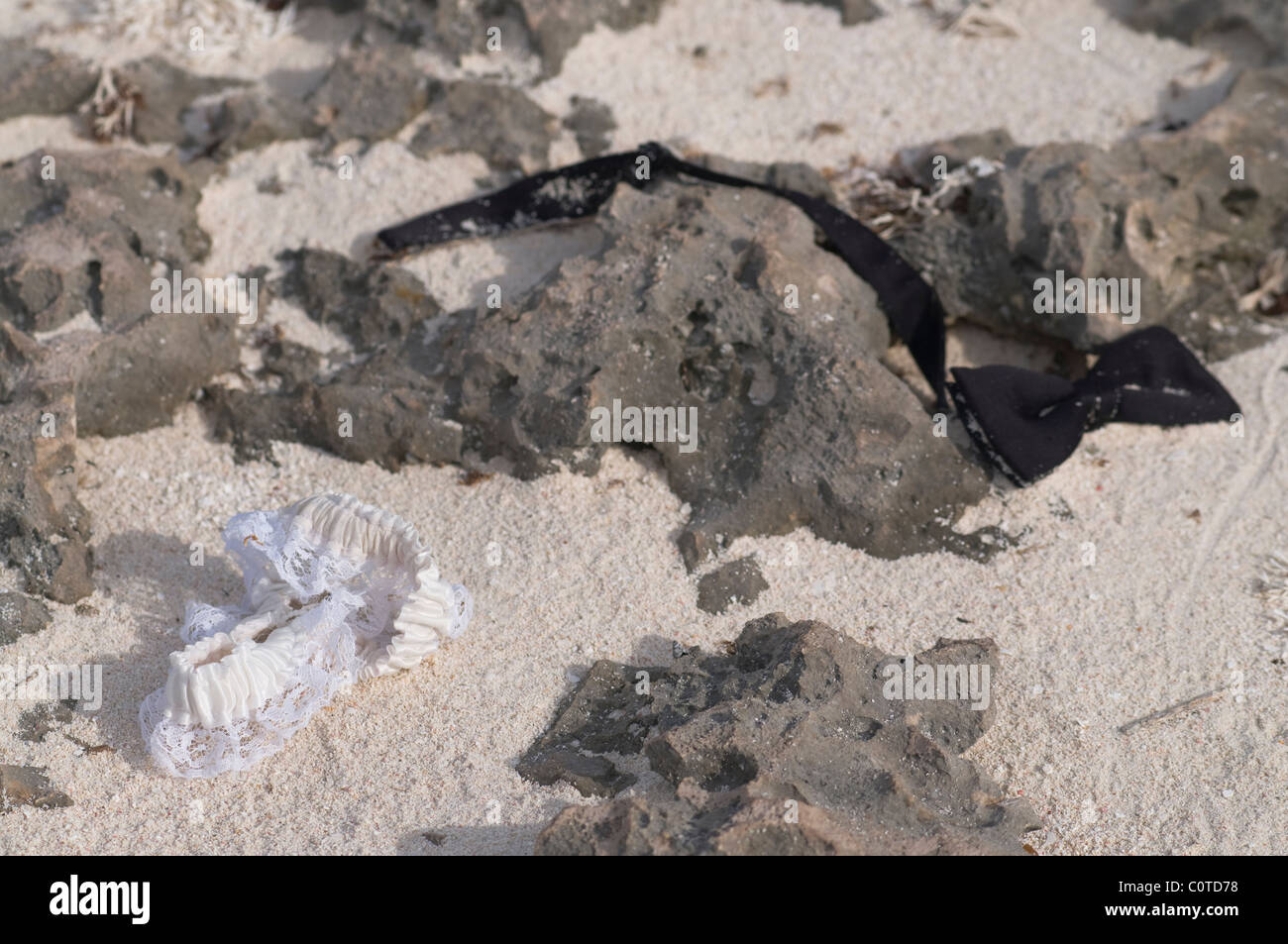 A garter and bow tie thrown around a beach in Aruba Stock Photo