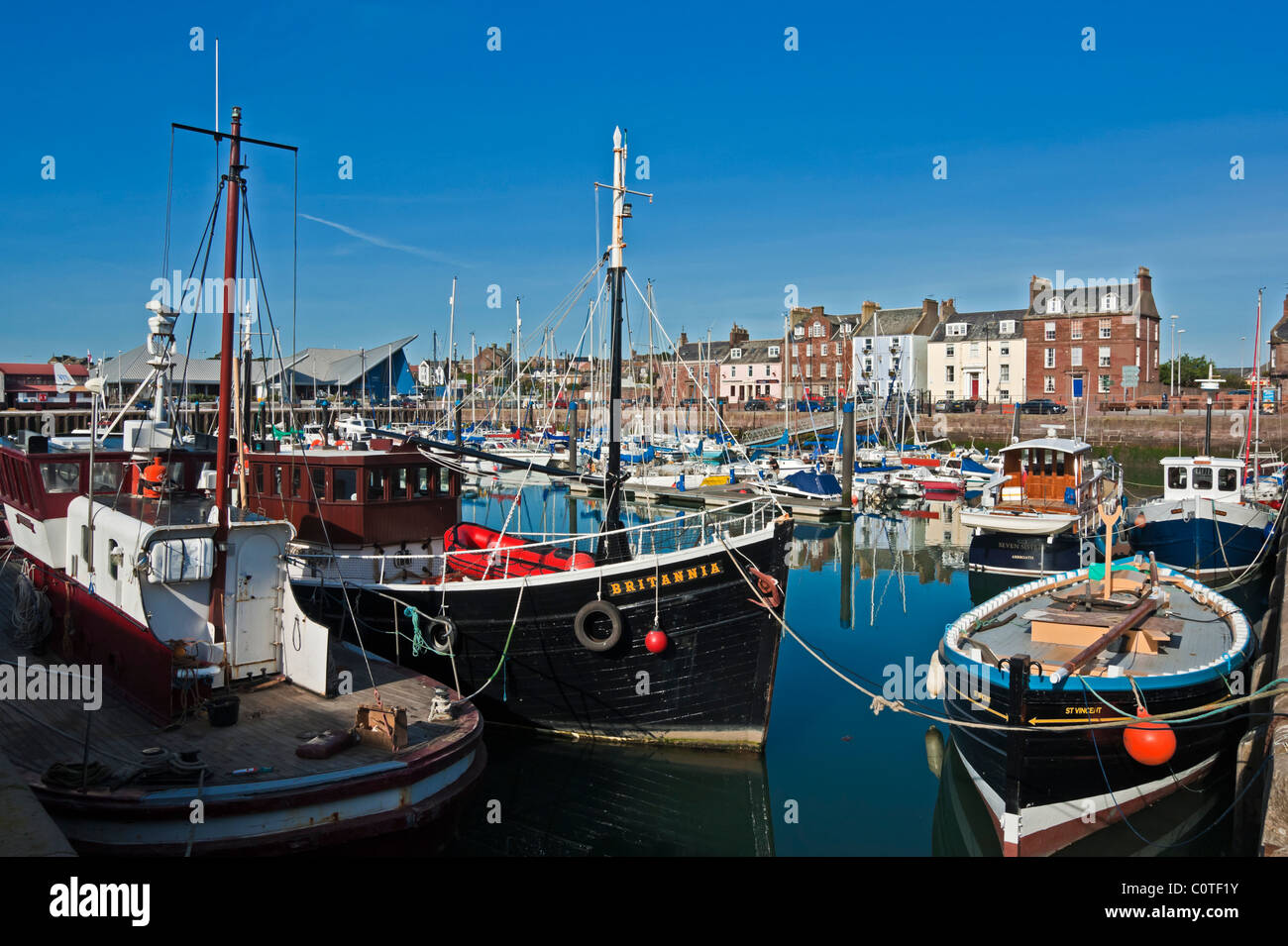 Arbroath Harbour in Scotland with vessels moored and Shore Street in the background Stock Photo