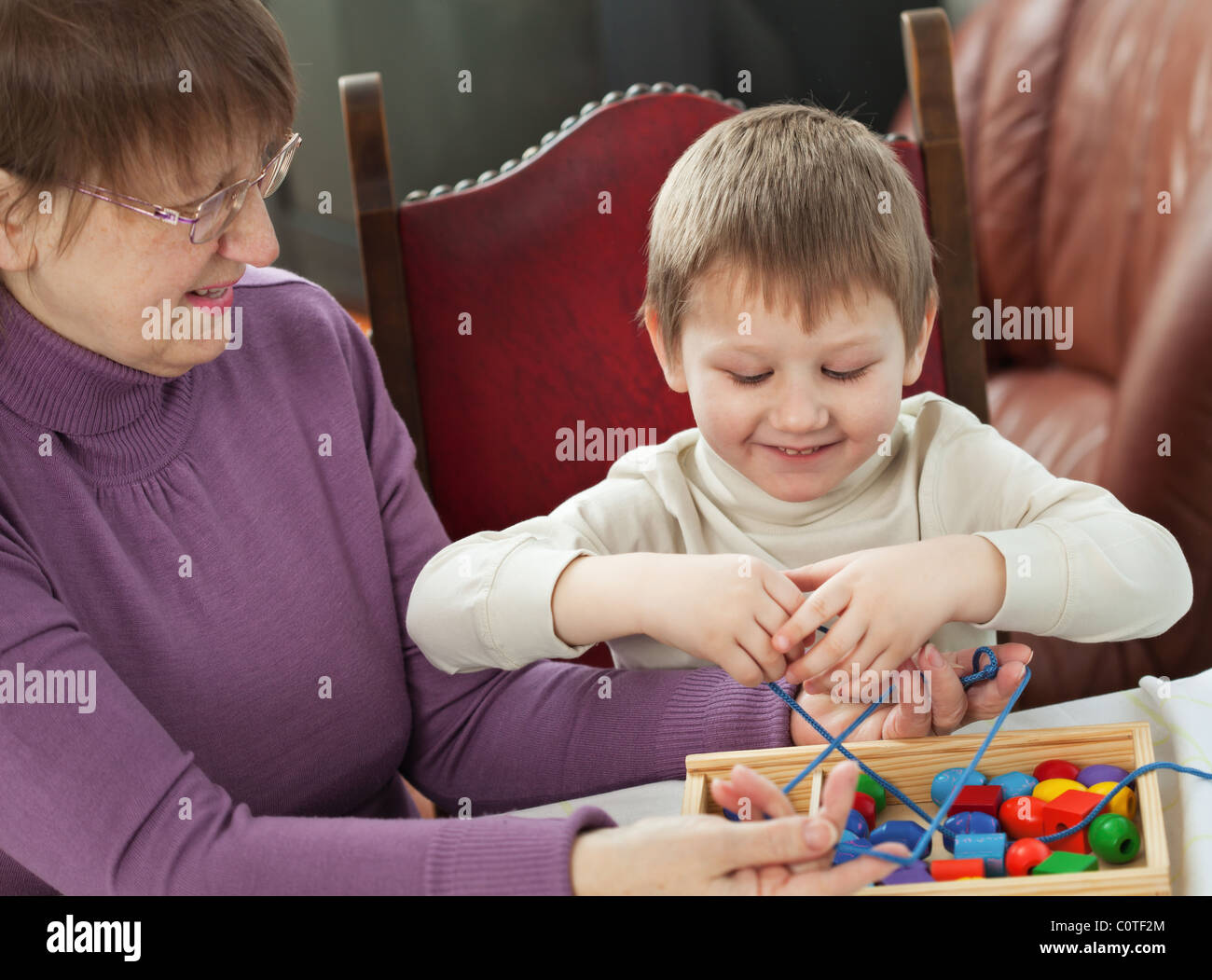 Granny is playing with her grandson at home Stock Photo