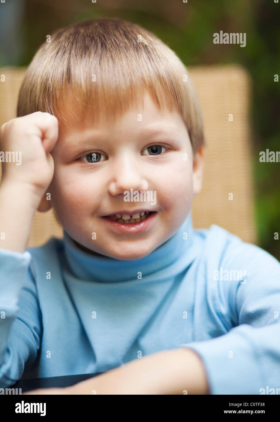 Portait of a cute smiling blond boy photographed indoors Stock Photo