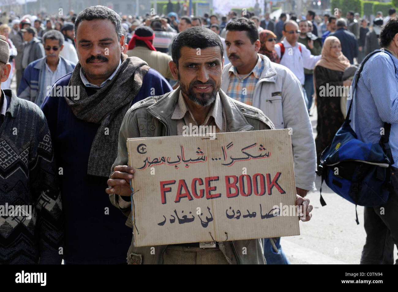 Anti-Mubarak protester holding a sign praising Facebook for helping to organise the protest in Tahrir square, Cairo, Egypt. Stock Photo