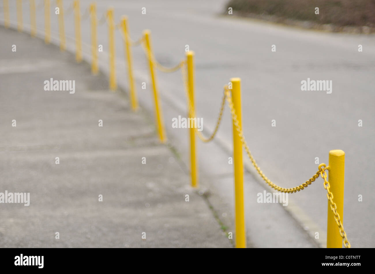 yellow chain railing remarking road and pedestrian walkway Stock Photo
