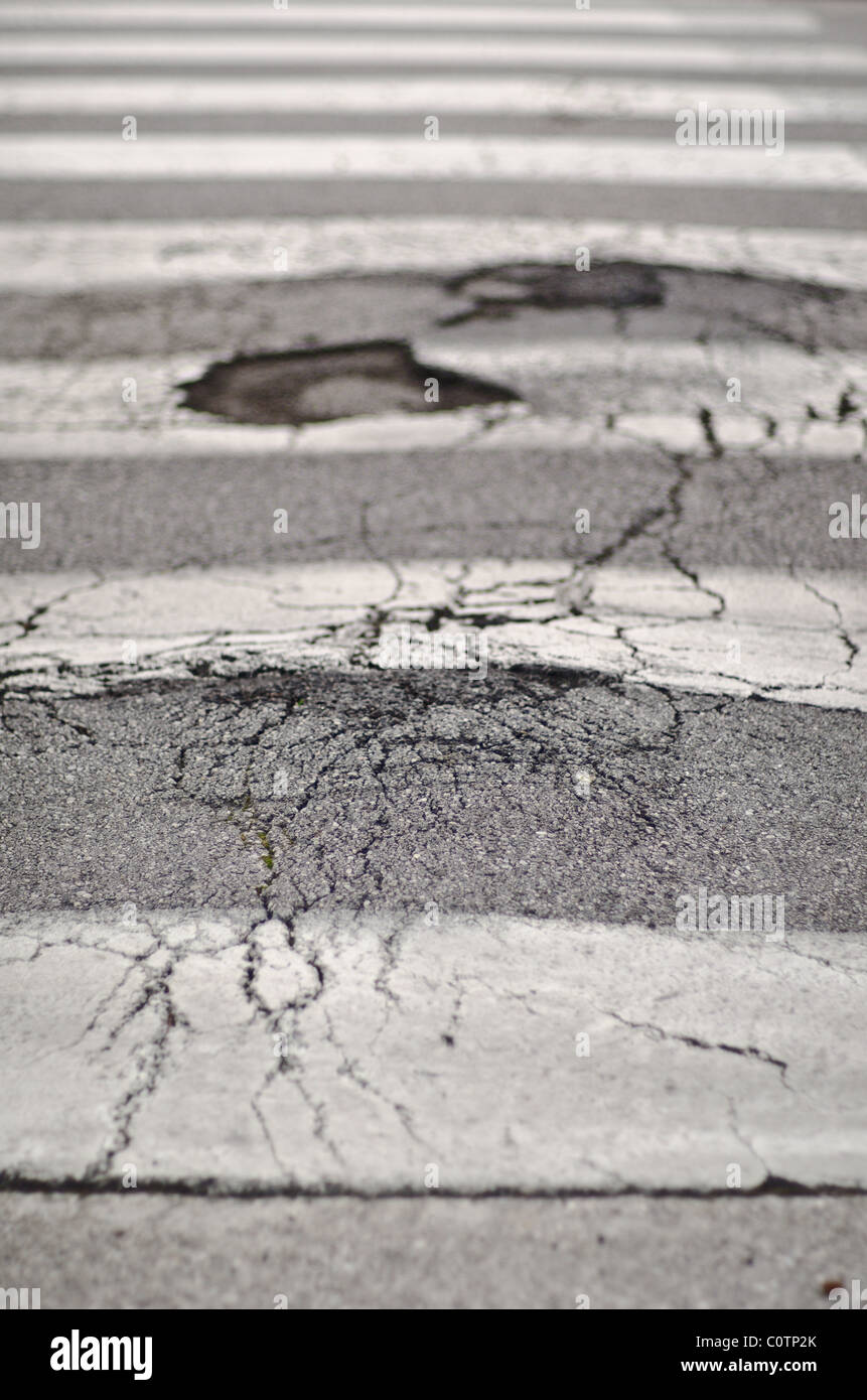 Hole in road on zebra crossing Stock Photo