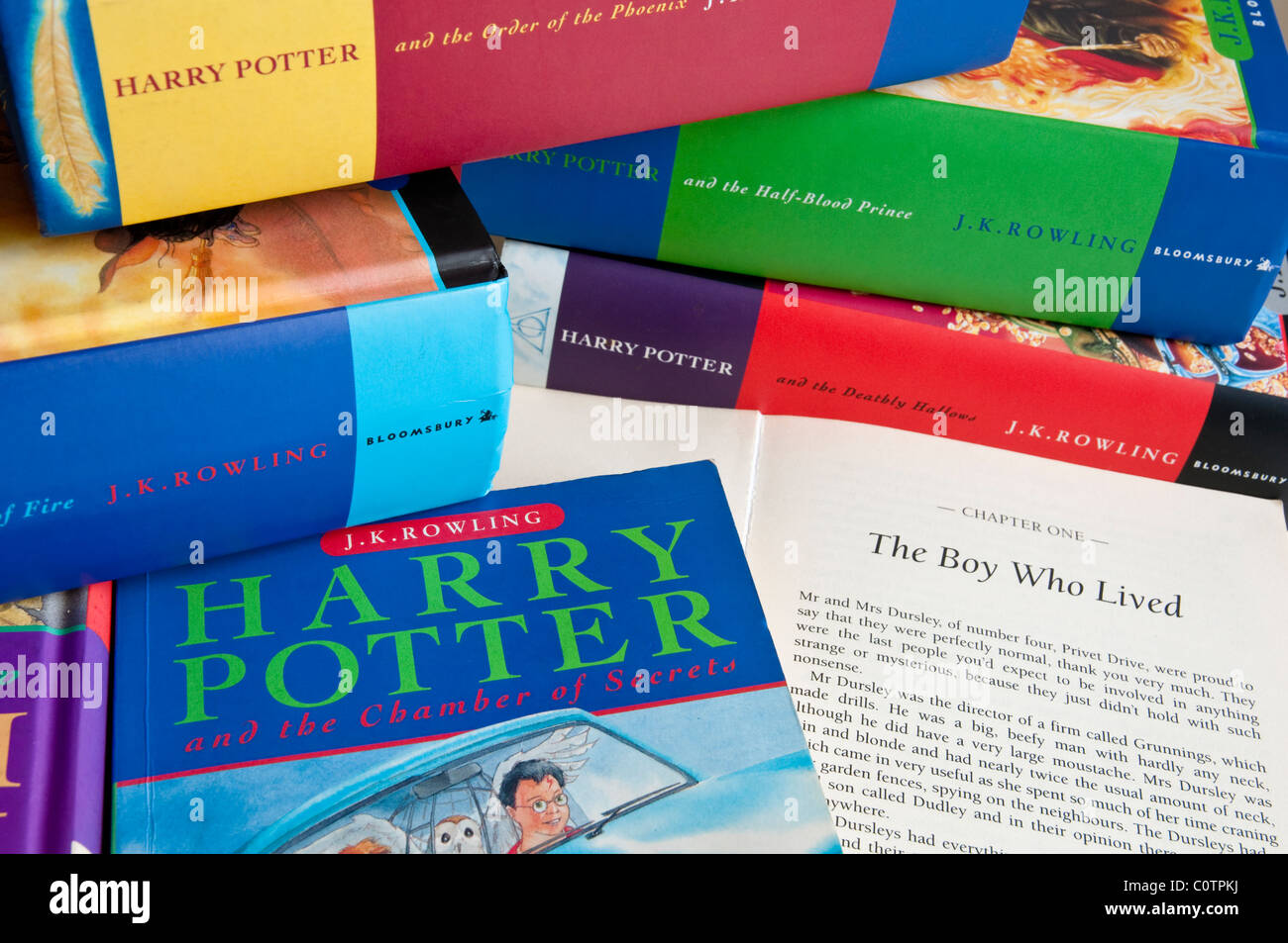 Pile of all the Harry Potter Books the first book is open and shows