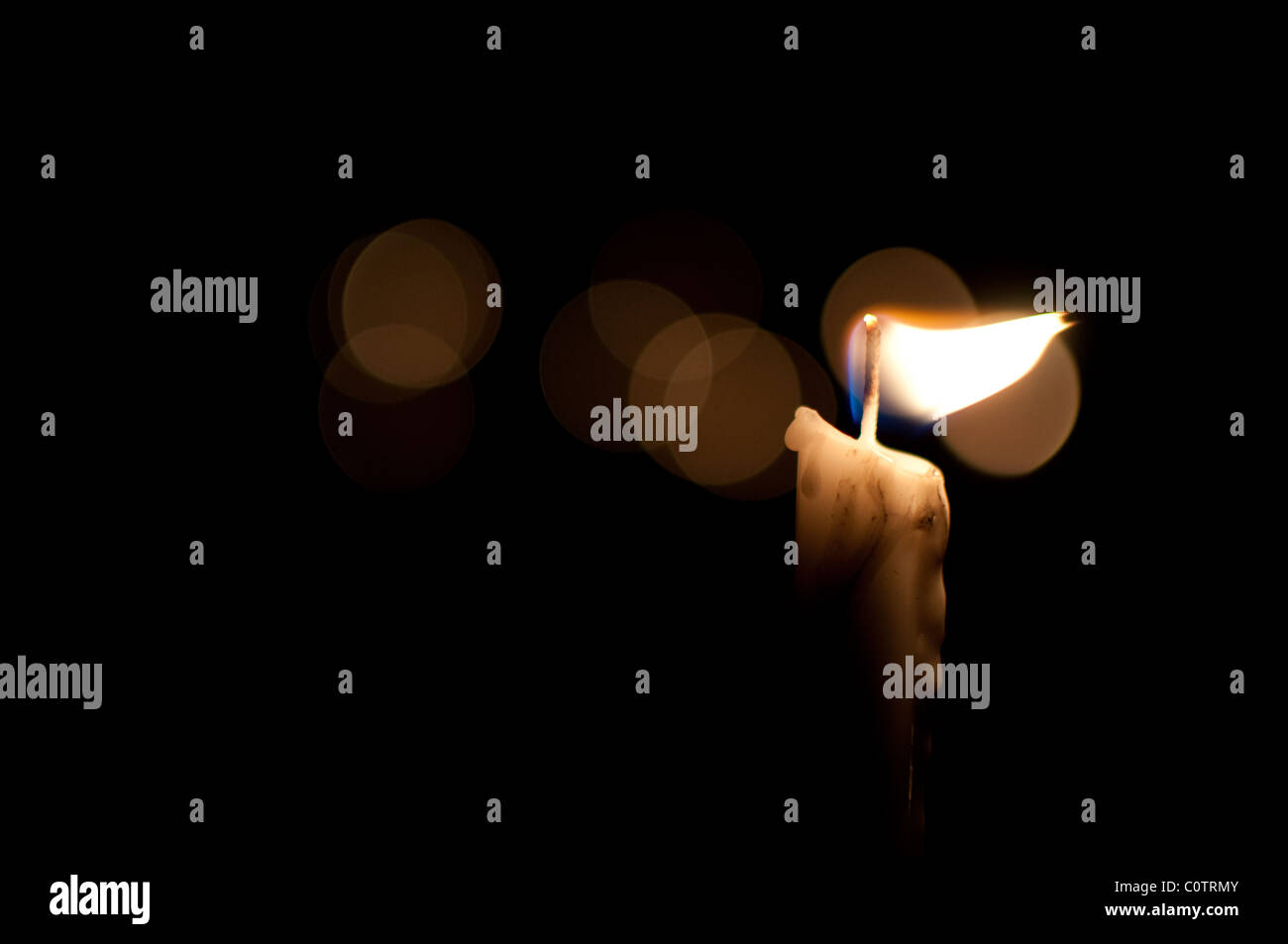 One candle among many burns in the darkness Stock Photo - Alamy