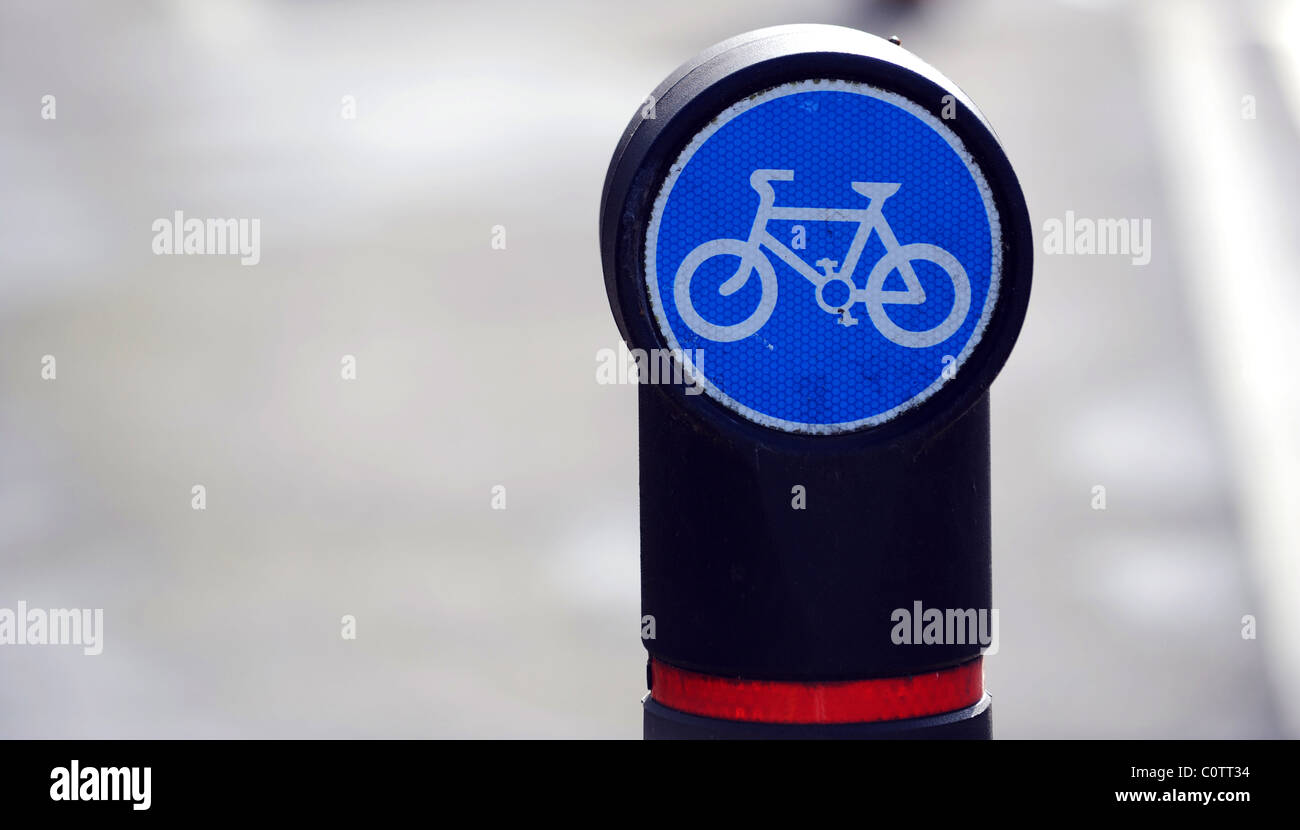A blue cycling sign on a bollard next to a cycle lane in Brighton Stock Photo
