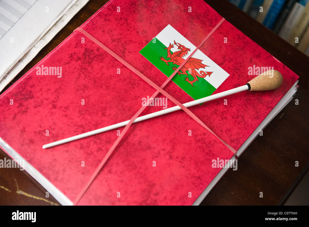 Welsh conductor's baton on file of manuscripts with red dragon flag sticker South Wales UK Stock Photo