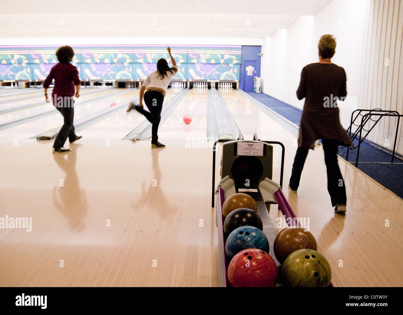 Three women ten pin bowling, "Strikes" bowling alley, Ely, UK Stock