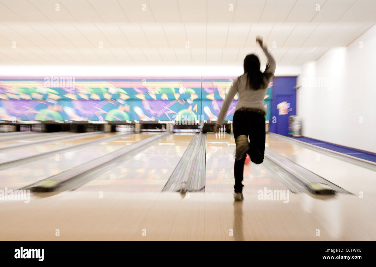 A young teen teenage woman ten pin bowling at 'Strikes' bowling alley, Ely, UK Stock Photo