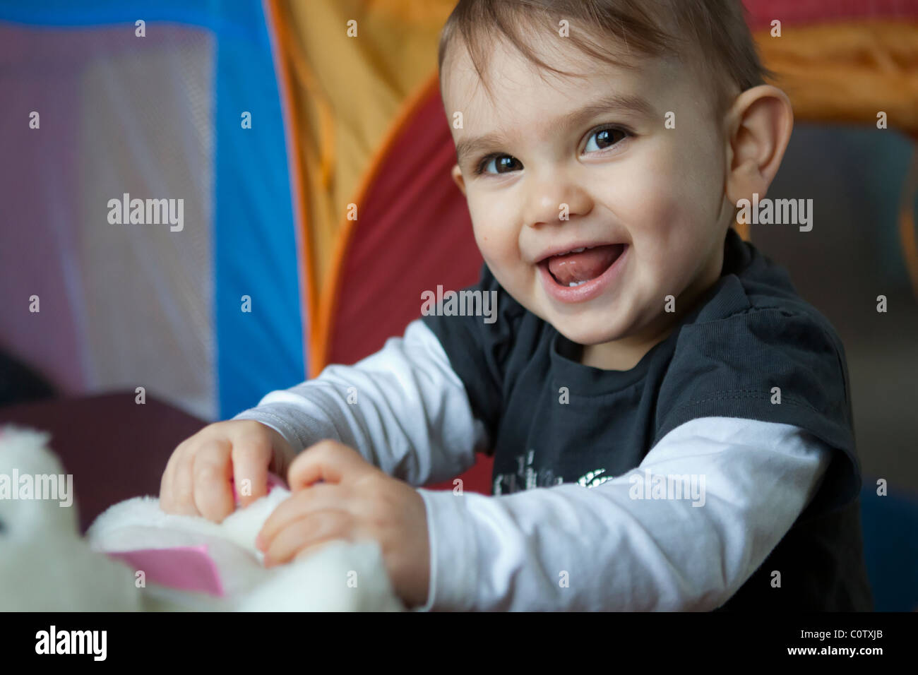 A little girl playing with her toys looking very happy Stock Photo - Alamy
