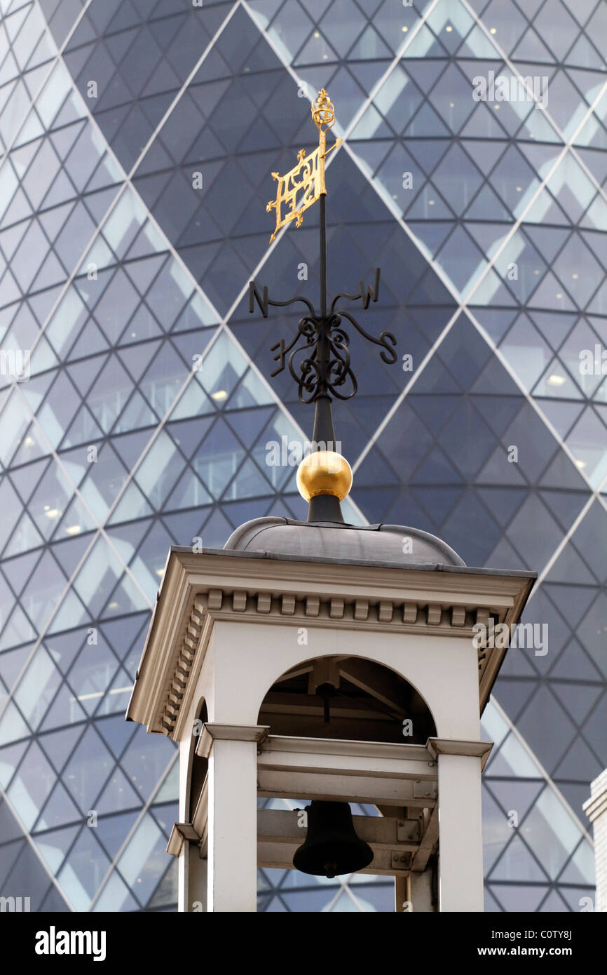UK. THE SWISS RE BUILDING WITH ST. HELEN'S CHURCH IN FOREGROUND IN THE CITY OF LONDON Stock Photo
